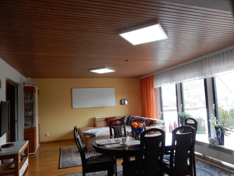 2 LED Panele im Wohnbereich an einer getäfelten Decke montiert